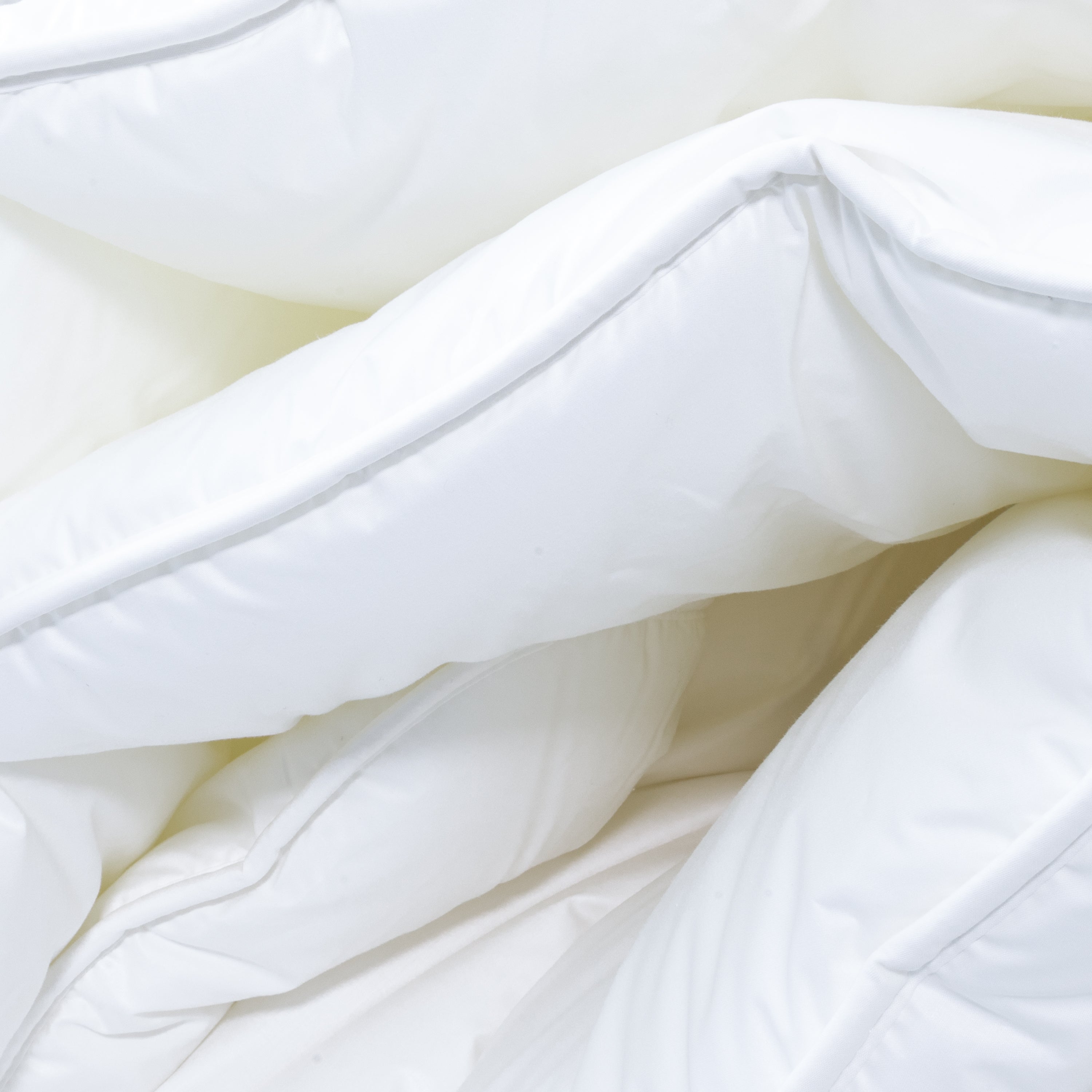 Seitenansicht der gefalteten Winterbettdecke Runa Bio mit weichem, voluminösem Material
