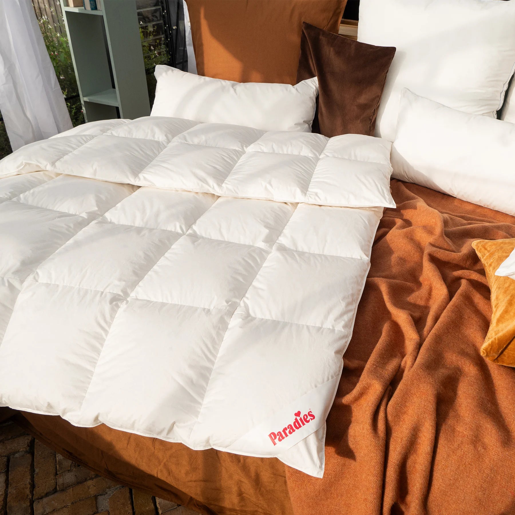 Elma liegt auf einem Bett mit orangener Wolldecke untendrunter