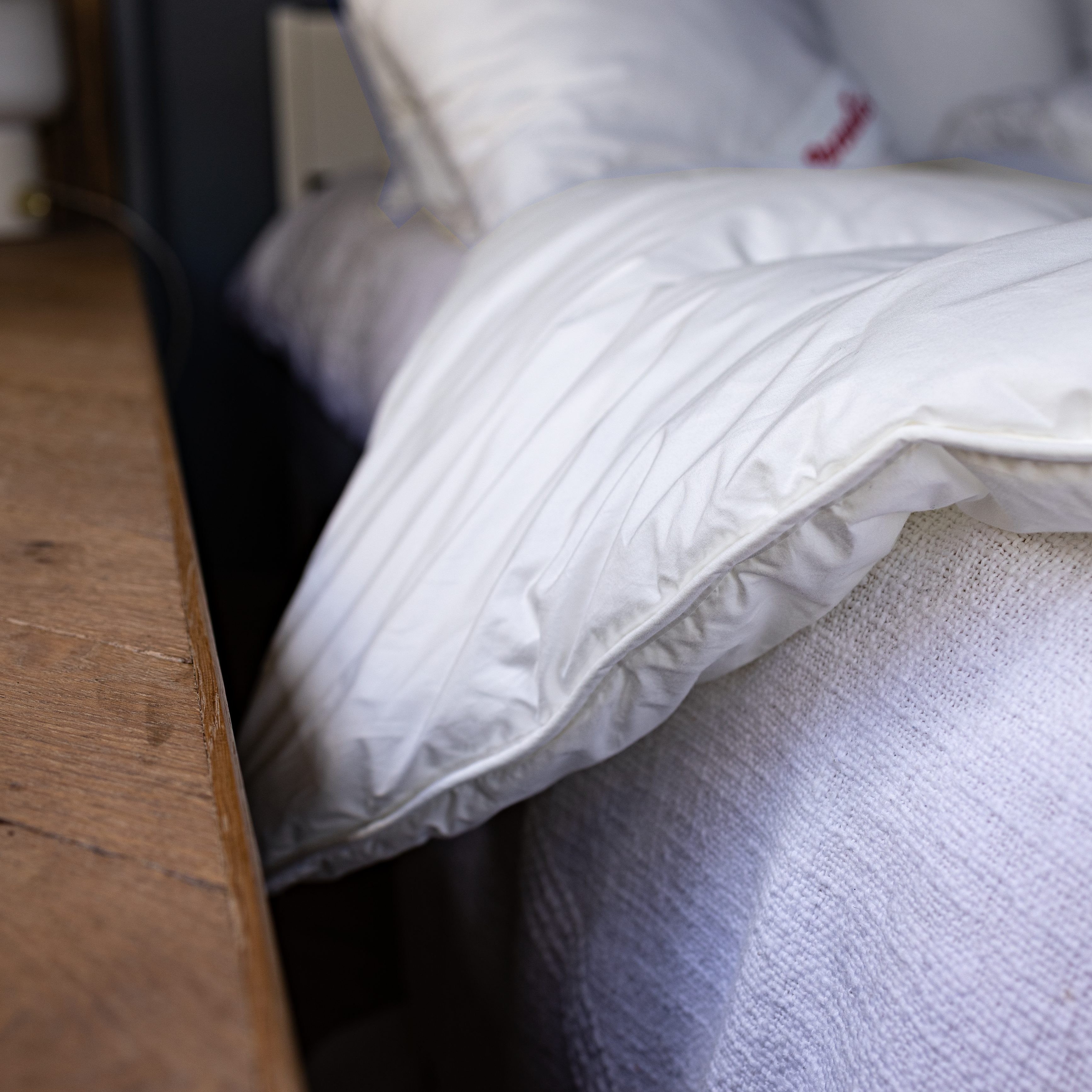 Nahaufnahme der Paradies Runa Bio Ganzjahresbettdecke, die leicht vom Bett herunter hängt